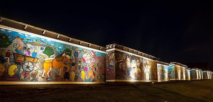 Mural wall lit at night by floodlighting