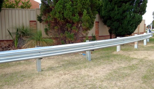 W beam metal crash barrier along a road shoulder