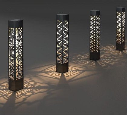 Perforated decorative bollard lights casting patterned shadows